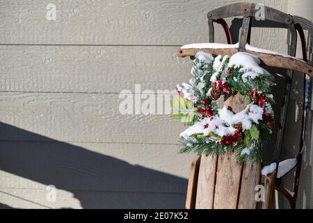 Christmas decorations and pine needles and red berries covered in snow in December Stock Photo