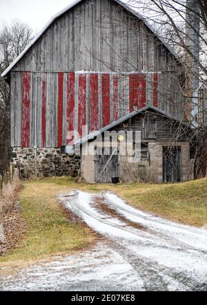weathered wooden old farm agricultural barn in the winter farmland Stock Photo