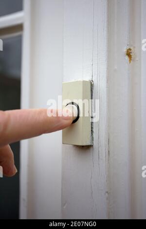 Finger pressing doorbell Stock Photo