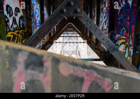street art graffiti on the rusty old iron railway bridge and steel grid supports Stock Photo