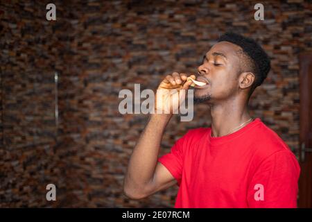 young african man eating chips Stock Photo