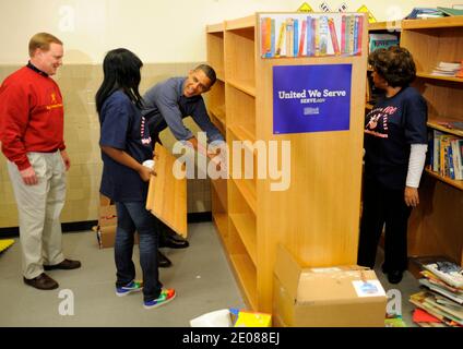 US President Barack Obama (c) assists in putting in book shelves as he joins volunteers in a library as they participate in a service project, at Browne Education Center, in Washington, DC, USA, on the Martin Luther King Jr national holiday, 16 January 2012. The project was in memory of the legacy of community service, promoted by the late civil rights leader, who was assassinated in 1968. Photo by by Mike Theiler/Pool/ABACAPRESS.COM Stock Photo