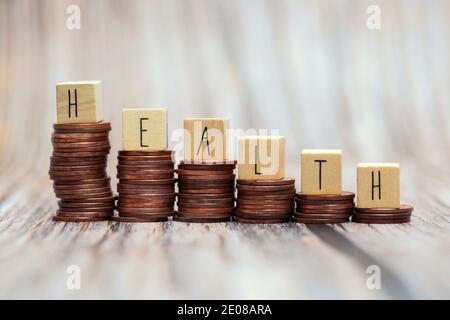 Word HEALTH on step stacked coins as graph up with white,gray background. Money savings or investment planning for life insurance and healthcare Stock Photo