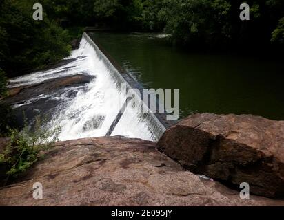 Beautiful view from the surface of rock and white foam water flows from a dam in a reservoir Stock Photo