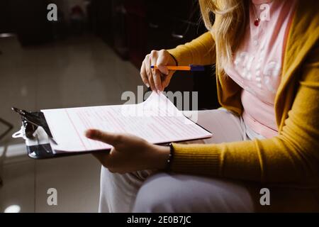 Latin woman hands writing and signing a document or a questionnaire in South America Stock Photo