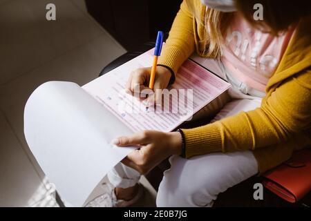 Latin woman hands writing and signing a document or a questionnaire in South America Stock Photo