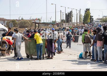 Thousands of asylum seekers wait in a line to register and enter the new Kara Tepe refugee camp north of Mytilene, the capital of the island of Lesbos.Refugees and Migrants were homeless after the fire in Moria hotspot, the former largest Refugee camp in Europe. People are wearing facemasks as a safety measure against the Covid-19 Coronavirus pandemic. Each person before entering the new camp has to be tested for Covid virus. Stock Photo