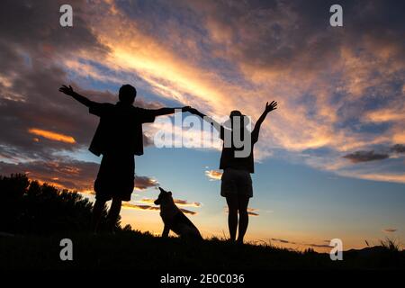 The happy couple and dog in the sunset Stock Photo