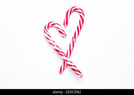 Two Candy Canes in Heart Shape with Red Bow Isolated on White Background. Stock Photo