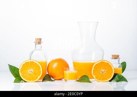 Oranges, oranges slices, orange leaves, and glass containers with orange juice isolated on white background. Stock Photo