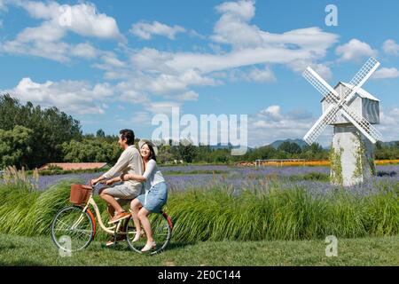 Young couples in the suburbs to ride a bicycle Stock Photo
