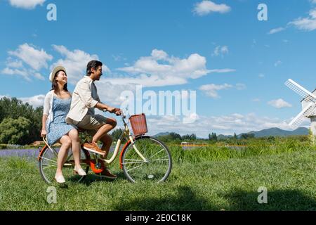 Young couples in the suburbs to ride a bicycle Stock Photo