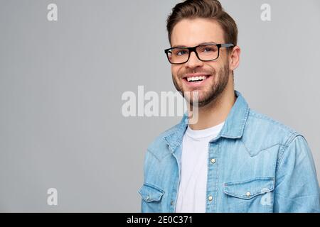 Portrait of young handsome caucasian man in jeans shirt over light background Stock Photo
