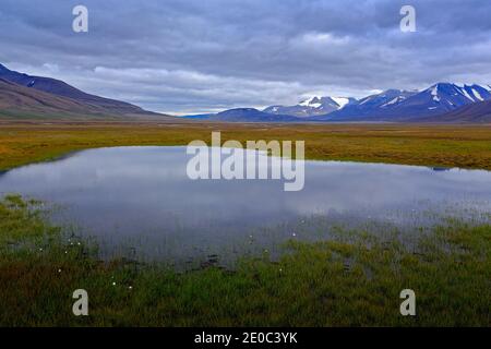 Norwegian typical landscape with lake and mountain, Longyearbyen, Svalbard. Grey clouds on the sky. Stock Photo