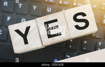 The word Yes on wooden blocks on computer keyboard. Business, motivation and education concept. Stock Photo