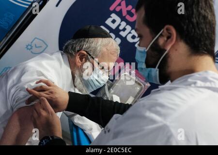 Jerusalem, Israel. 31st Dec, 2020. Nurses administer COVID-19 vaccines to elderly people 60 and over at the Pais Arena Sports Complex in Jerusalem, converted into a Coronavirus vaccination center. The number of Israeli citizens who have received the first of two doses of the Pfizer BioNTech vaccine is expected to reach 1M by the end of the day as a mass vaccination campaign continues, as does COVID-19 infection in the general public. Credit: Nir Alon/Alamy Live News Stock Photo
