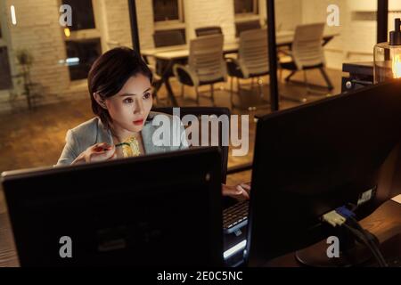 Young woman in the office to work overtime to eat instant noodles Stock Photo