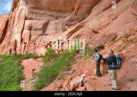 Park ranger and visitor at Betatakin ruin in Tsegi Canyon, Navajo National Monument, Shonto Plateau, Arizona, USA Stock Photo