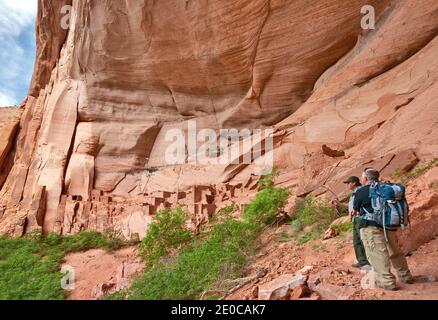 Park ranger and visitor at Betatakin ruin in Tsegi Canyon, Navajo National Monument, Shonto Plateau, Arizona, USA Stock Photo