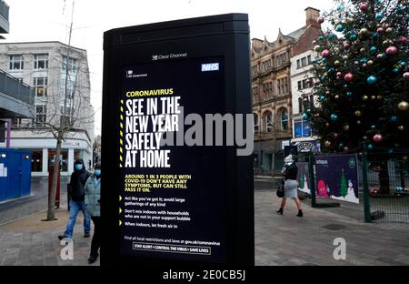 Leicester, Leicestershire, UK. 31st December 2020. People walk past a warning sign after the city entered tier 4 of coronavirus restrictions.  Credit Darren Staples/Alamy Live News. Stock Photo