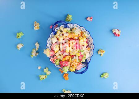 Colorful popcorn in a bowl on blue background  Stock Photo