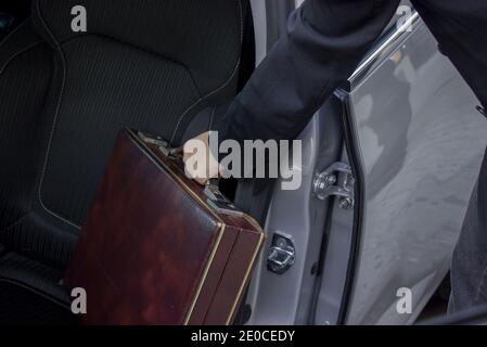 Young business woman takes her briefcase from her car to go to work. Close up of an unrecognizable woman holding her briefcase. Girl Boss Concept 2021 Stock Photo