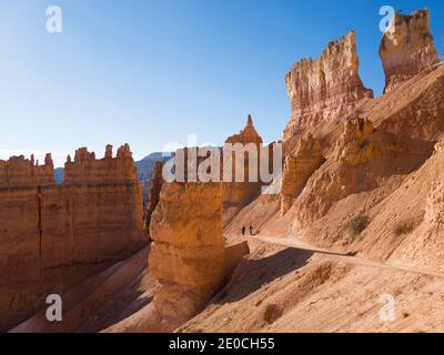 Two hikers heading down the Navajo Loop Trail below Sunset Point, Bryce Canyon National Park, Utah, United States of America Stock Photo