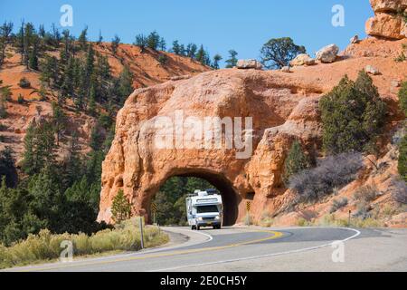 Motorhome emerging from red rock tunnel on Utah State Route 12, Red Canyon, Dixie National Forest, Utah, United States of America Stock Photo