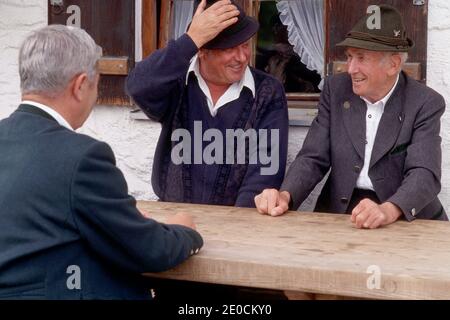 Germany /Bavaria / Elderly Bavarian man sitting at table and laughing Stock Photo