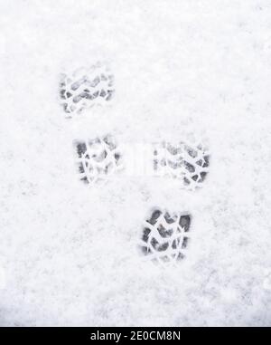 Two boot prints in the snow in winter white Stock Photo