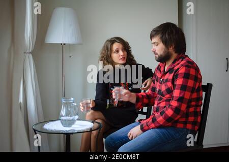 Handsome bearded man dressed in lambersexual style clothes is hugging her young woman in black warm dressed during celebration St. Valentine Day Stock Photo