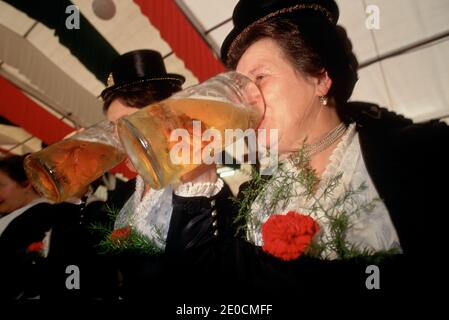 Germany /Bavaria /Munich/ Oktoberfest - Bavarian festival with two woman doing a beer drinking competition . Stock Photo