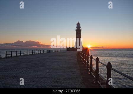 Sunrise at Roker Pier and Lighthouse which reaches out from the North Sea coast at Sunderland, Tyne and Wear, North-East England. Stock Photo