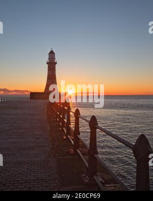 Sunrise at Roker Pier and Lighthouse which reaches out from the North Sea coast at Sunderland, Tyne and Wear, North-East England. Stock Photo