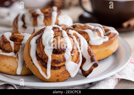 Closeup of cinnamon rolls with white icing on a plate Stock Photo
