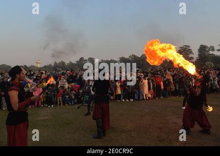 Lahore, Pakistan. 30th Dec, 2020. Pakistani large numbers of families sit in the ground take part during “Family Winters Festival” at Race Course Jilani Park in Provincial capital city Lahore. Families are enjoying with the Dinosaur model and breathing Fire from mouth show during “Family Winters Festival” at Race Course Jilani Park. (Photo by Rana Sajid Hussain/Pacific Press) Credit: Pacific Press Media Production Corp./Alamy Live News Stock Photo