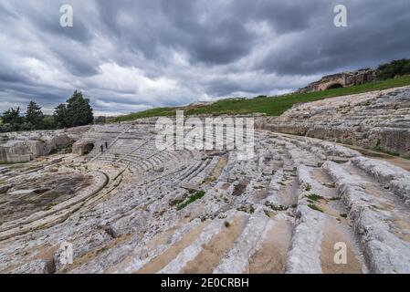 Seating sections of ancient ruins of Greek Theater from 5th century BC in Neapolis Archaeological Park in Syracuse city, Sicily Island, Italy Stock Photo