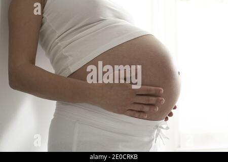 GREAT BRITAIN / England / London / Pregnant woman holding her belly Stock Photo