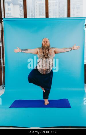 Funny fat man doing yoga meditation, funny and ironic character stock photo
