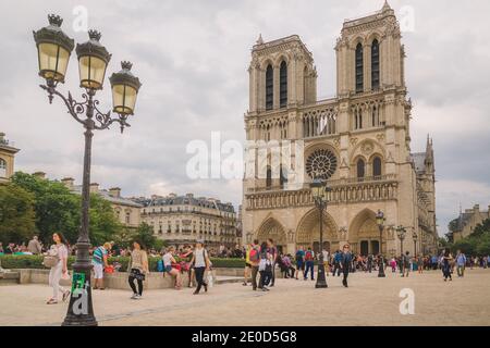 Paris, France - June 14 2015: Tourists and locals alike gather in front of the famous Notre Dame cathedral in Paris, France Stock Photo