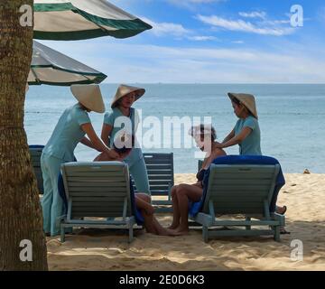 Vietnamese woman masseurs giving a massage on the beach at Phu Quoc