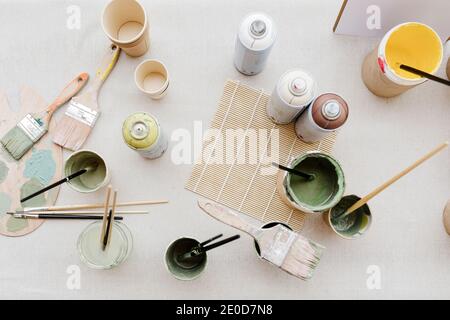 Top view of various paint and brushes placed on table in creative workshop Stock Photo