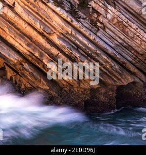 Beautiful schist cliff details in Baleal island with ocean waves crashing in Peniche, Portugal Stock Photo
