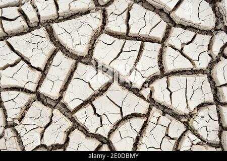 Top view closeup textured background of rough cracked barren waterless soil during drought Stock Photo