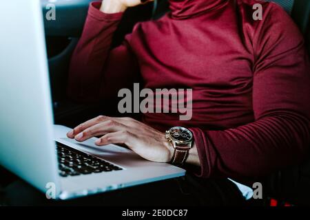 Unrecognizable crop African American male entrepreneur using touchpad and browsing laptop while working on project remotely Stock Photo