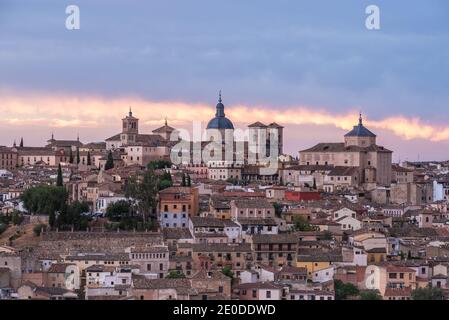 Amazing cityscape with aged stone buildings located on hill on background of cloudy sky in evening Stock Photo