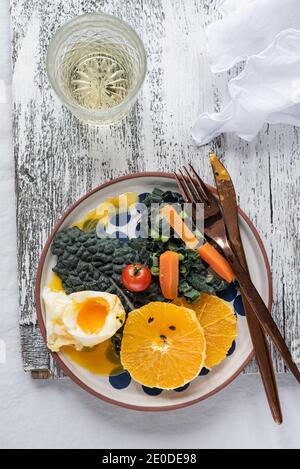 Top view of delicious poached egg on plate with fresh fruits and vegetables served on table for healthy breakfast Stock Photo
