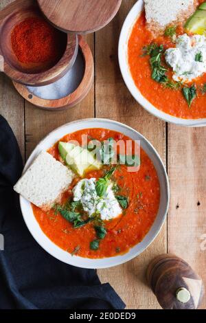 Delicious sour cream with basil in ceramic spoon on white background ...