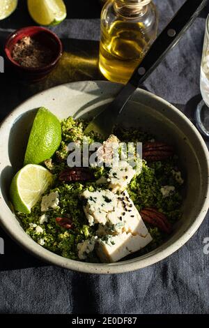 From above bowl with broccoli salad with couscous placed on dark fabric napkin Stock Photo