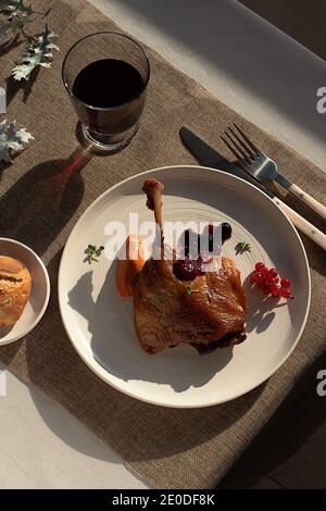 From above delicious fried duck confit on white ceramic plate placed on table of modern restaurant Stock Photo
